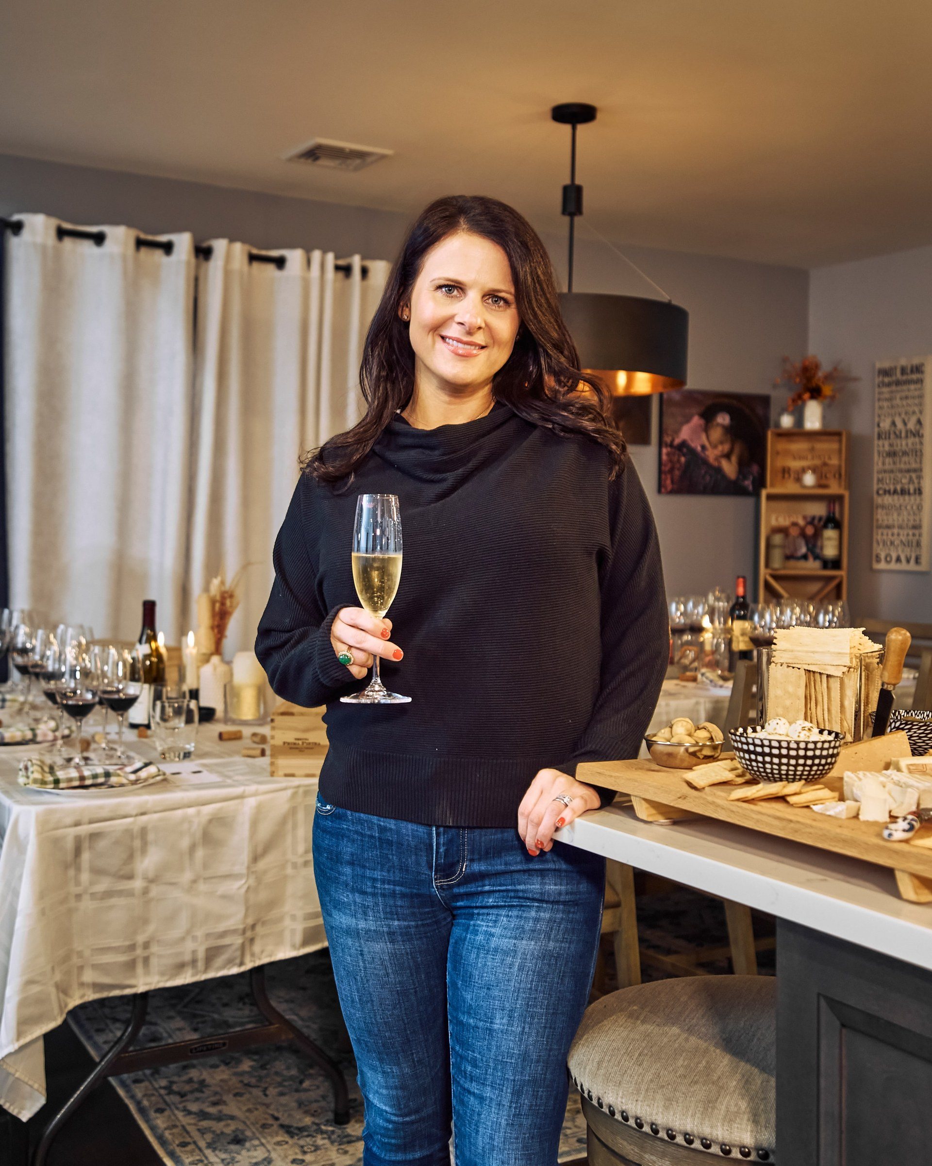 Alicia Abaté with a glass beside the set table