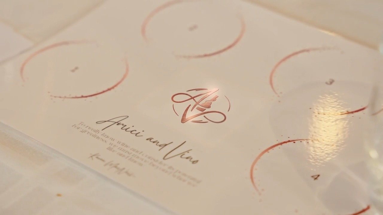 The tasting placemat: numbered circles in rose copper round the monogram