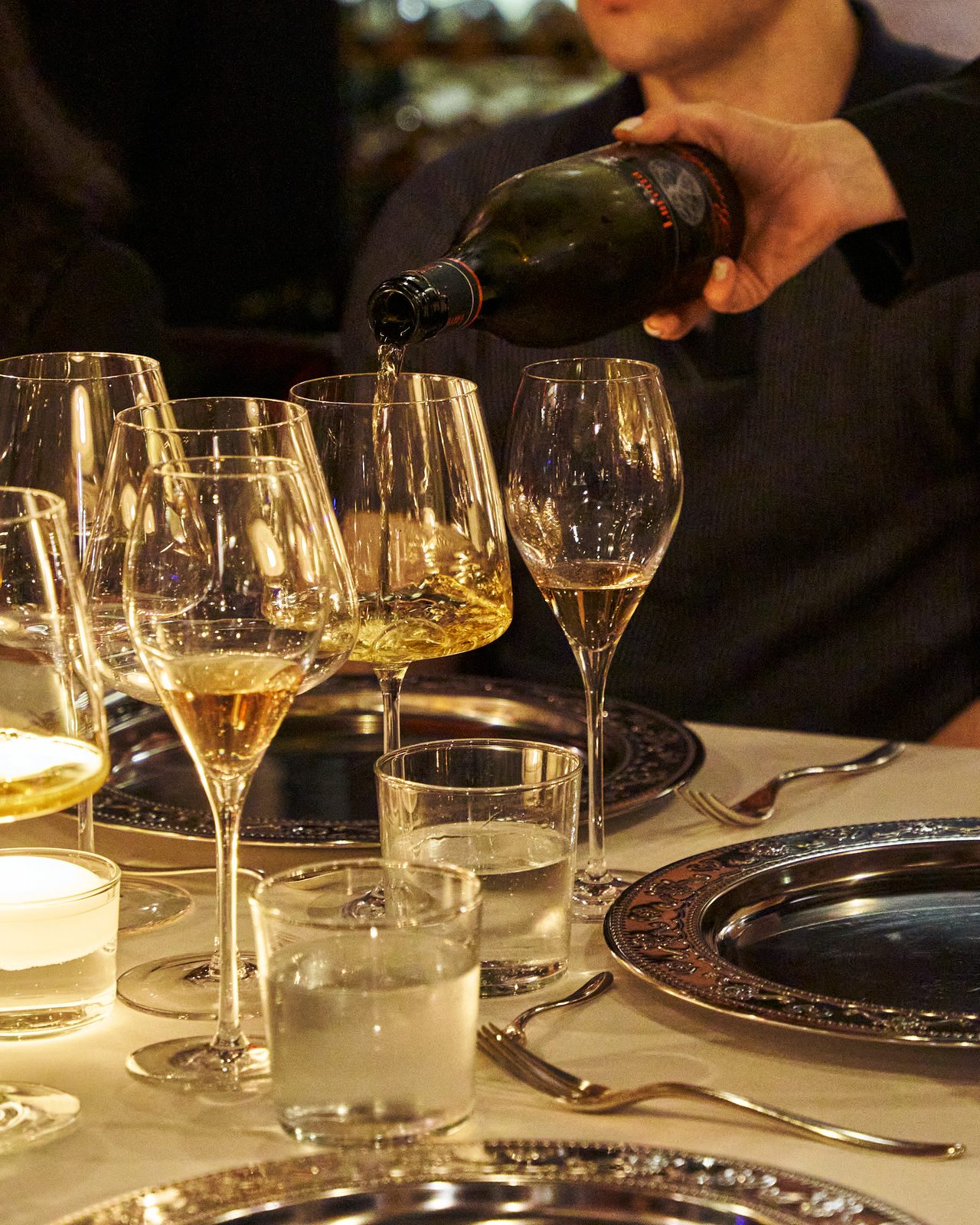 Wine poured into a row of glasses at the table